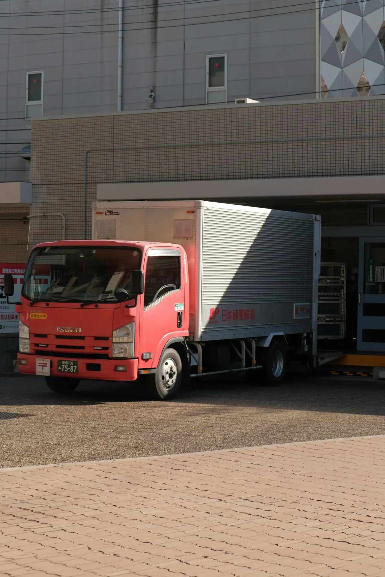 Red and white truck standing in a delivery docking bay